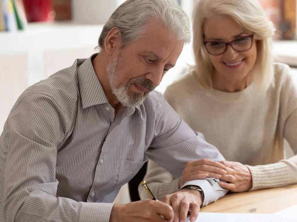 Retired couple signing documents.